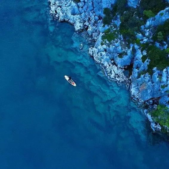 Paddleboarding along rocky coastline